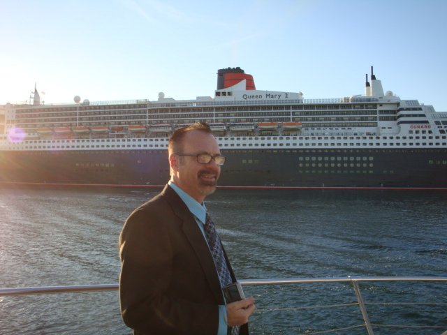 Photo of Queen Mary 2 at the Port of Los Angeles with person standing in foreground