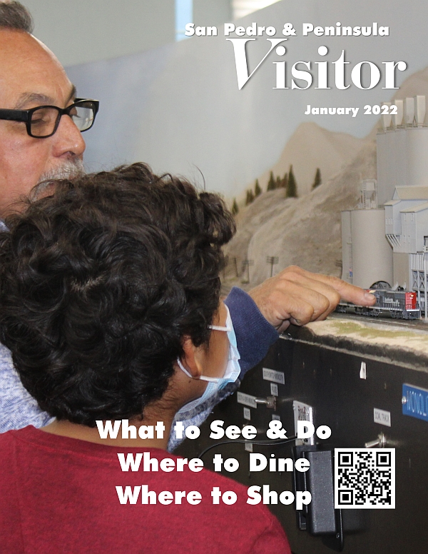 Cover of San Pedro & Peninsula Visitor magazine showing Jessie Munoz of the Belmont Shore Railroad Club working with a young member on the club's model train layout